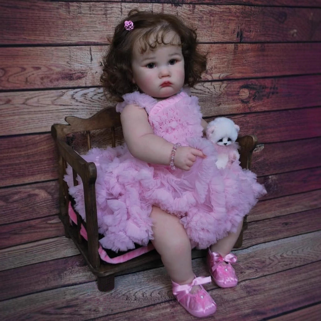 Poupée Reborn Charlotte de 60 cm yeux ouverts et cheveux bruns en robe rose