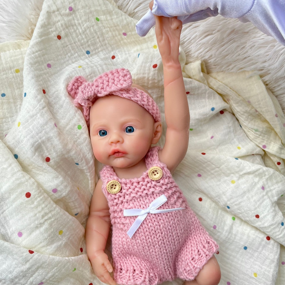 Bébé reborn fille de 30 cm en silicone vêtue d'une salopette rose tricotée