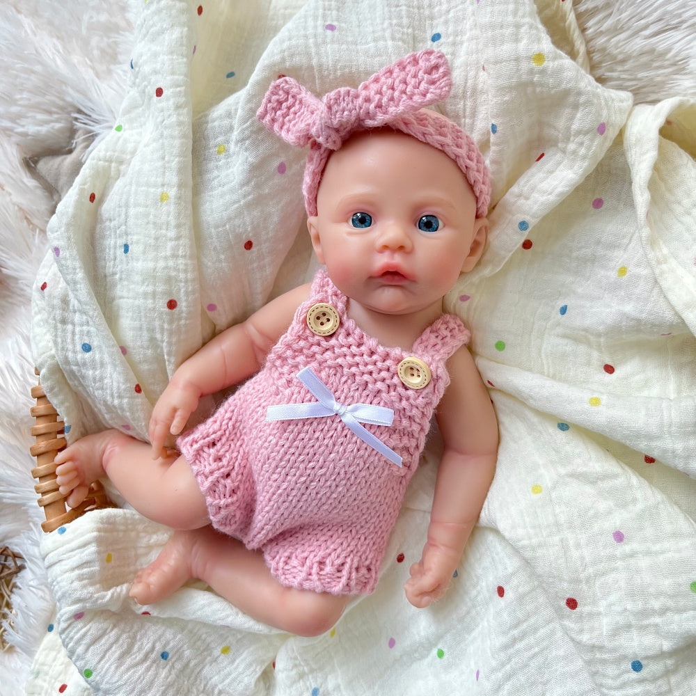 Bébé reborn fille de 30 cm en silicone vêtue d'une salopette rose tricotée