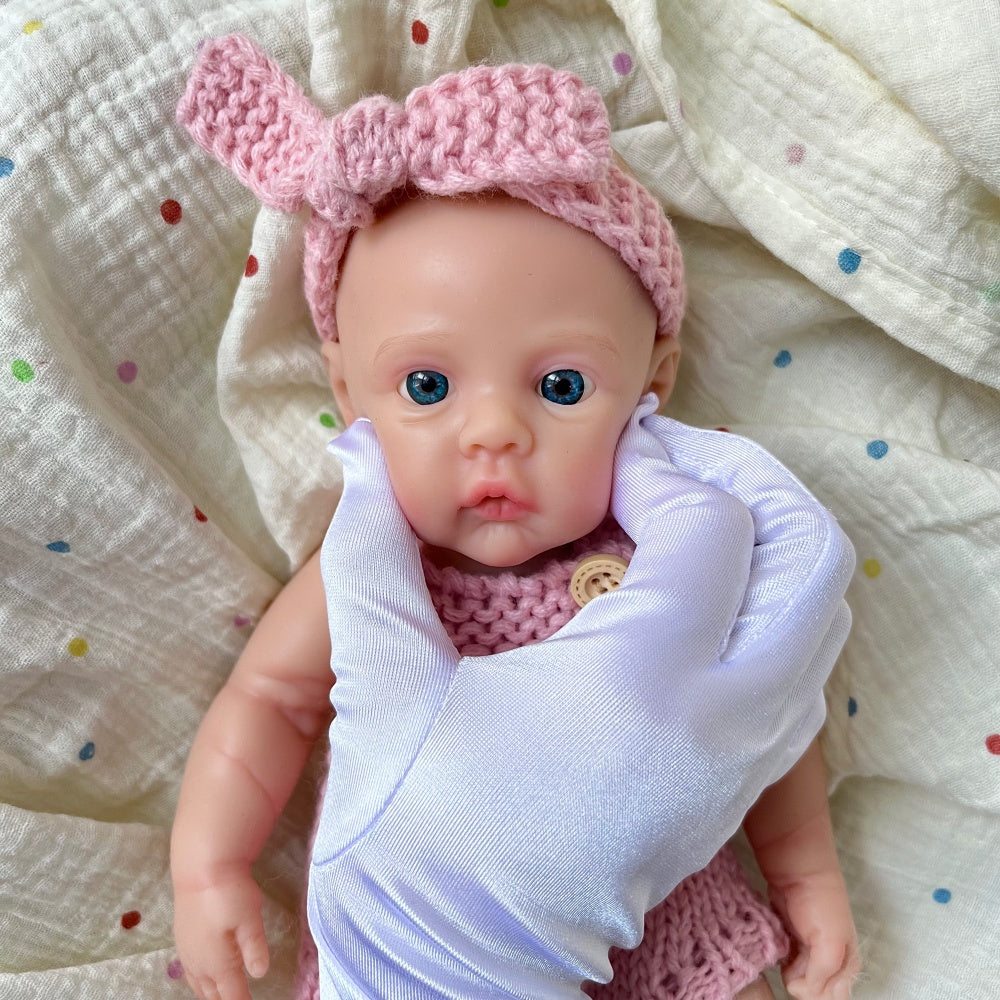 Bébé reborn fille de 30 cm en silicone vêtue d'une salopette rose tricotée