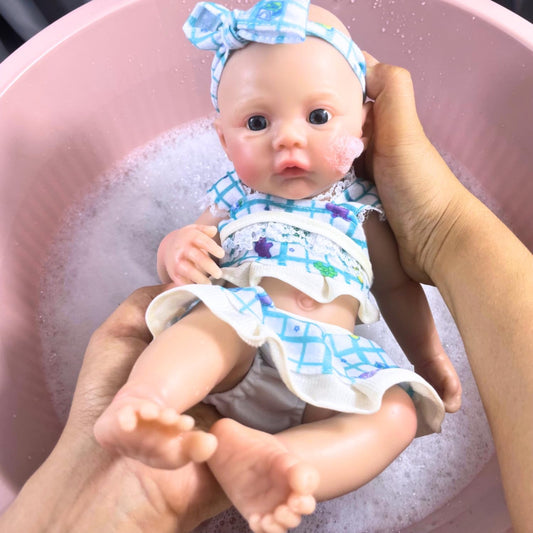 Bébé reborn fille de 30 cm en silicone vêtue d'une robe bleue à fleurs