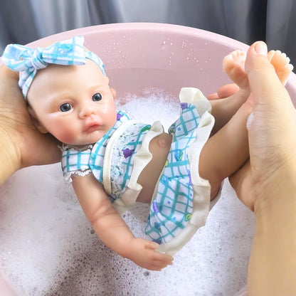 Bébé reborn fille de 30 cm en silicone vêtue d'une robe bleue à fleurs