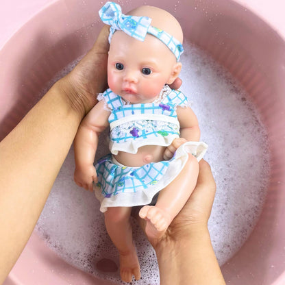 Bébé reborn fille de 30 cm en silicone vêtue d'une robe bleue à fleurs