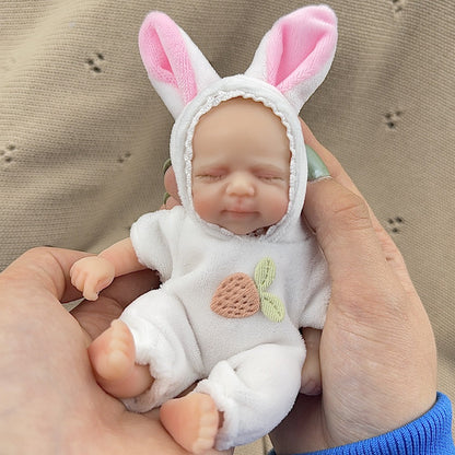 Poupée reborn miniature Pascale de 15 cm yeux fermés en silicone vêtue d'une tenue de lapin blanc