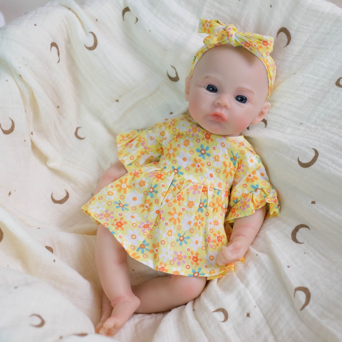 Bébé reborn de 30 cm en silicone souple fille vêtue d'une robe à fleurs jaunes