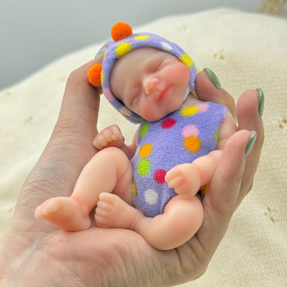 Poupée reborn miniature Pascale de 15 cm yeux fermés en silicone vêtue d'une tenue à pois violets