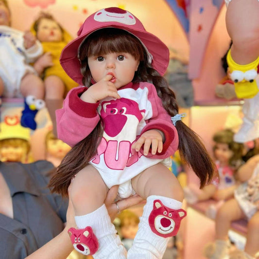 Bébé reborn fille de 55/60cm aux cheveux longs vêtue d'un adorable ourson rose