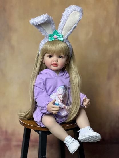 Bébé reborn de 55 cm yeux ouverts longs cheveux vêtue de vêtements violets et d'un serre-tête à oreilles de lapin - Betty