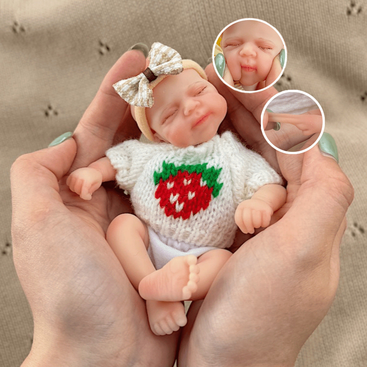 Poupée reborn miniature Pascale de 15 cm yeux fermés en silicone vêtue d'un pull blanc à fraises