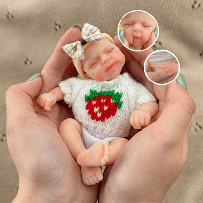 Poupée reborn miniature Pascale de 15 cm yeux fermés en silicone vêtue d'un pull blanc à fraises