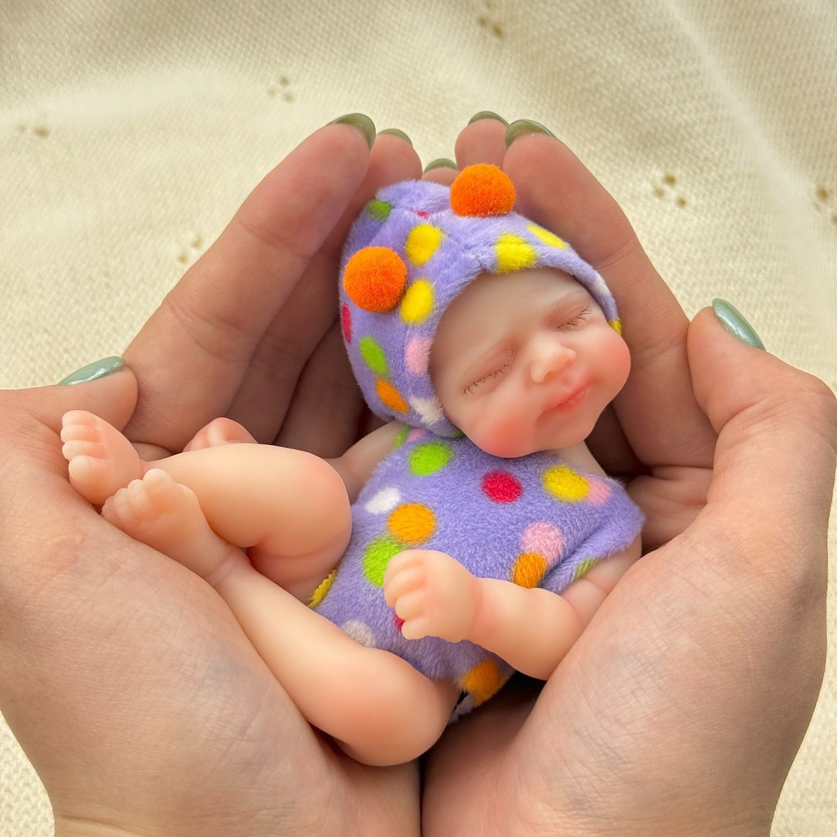 Poupée reborn miniature Pascale de 15 cm yeux fermés en silicone vêtue d'une tenue à pois violets
