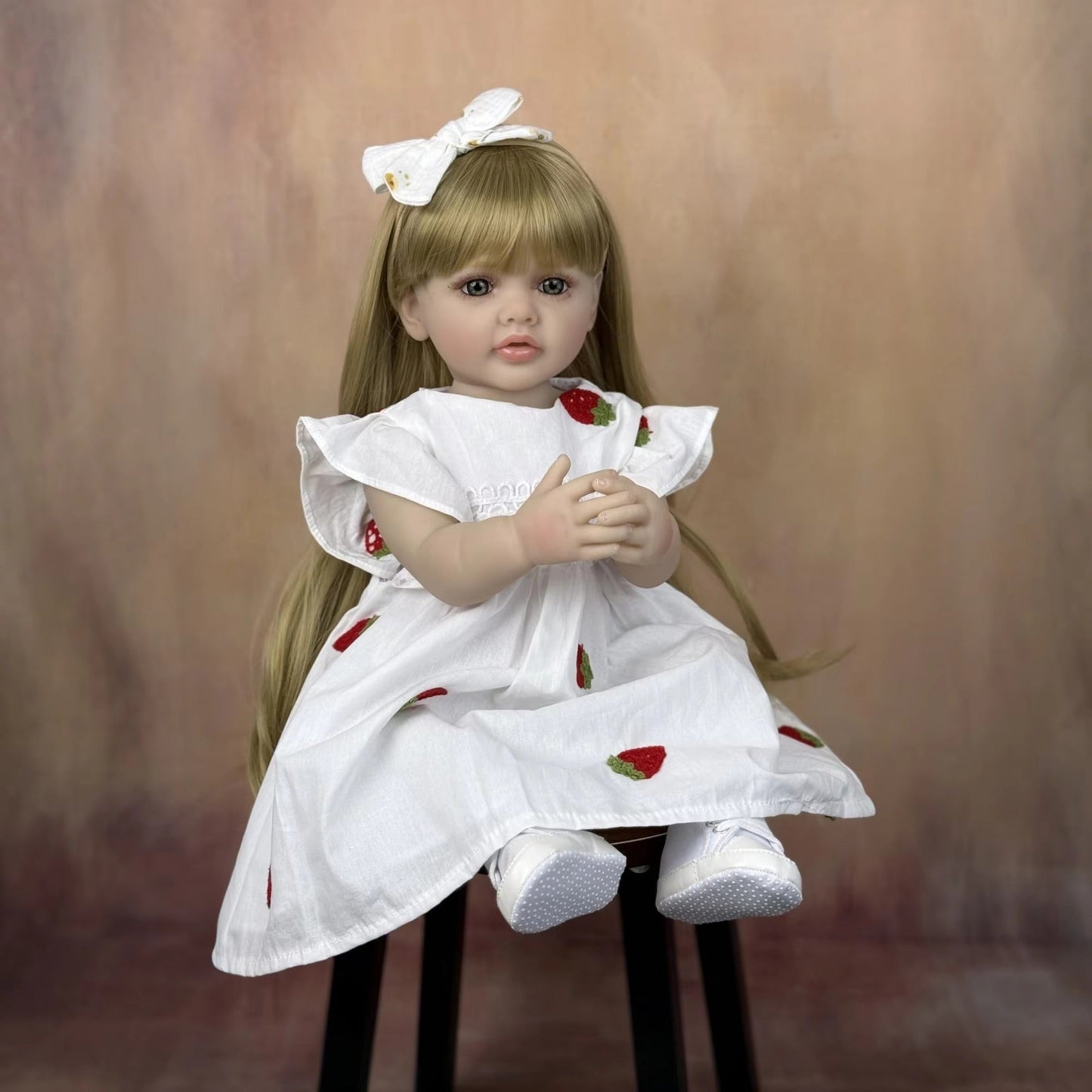 Bébé reborn Betty 55 cm yeux ouverts longs cheveux blonds en robe blanche