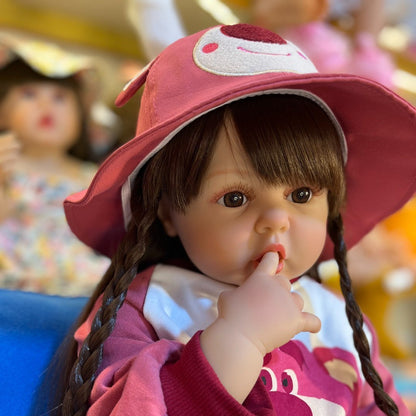 Bébé reborn fille de 55/60cm aux cheveux longs vêtue d'un adorable ourson rose