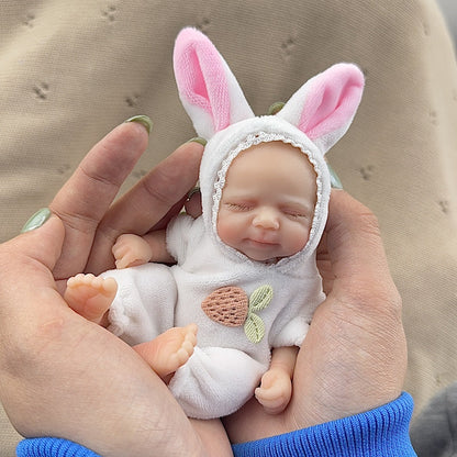 Poupée reborn miniature Pascale de 15 cm yeux fermés en silicone vêtue d'une tenue de lapin blanc