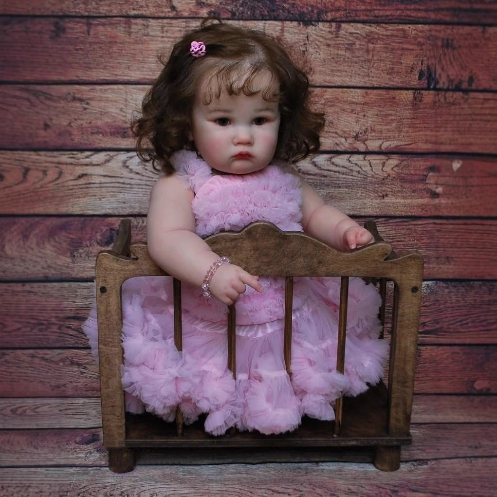 Poupée Reborn Charlotte de 60 cm yeux ouverts et cheveux bruns en robe rose