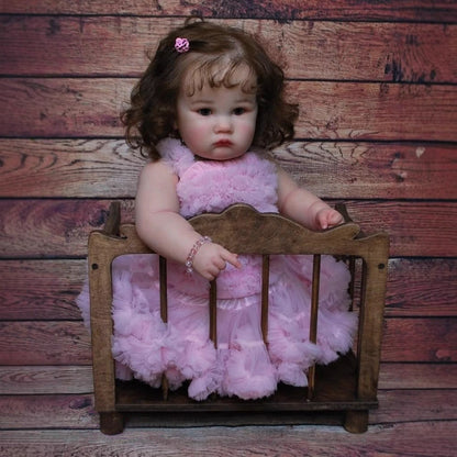 Poupée Reborn Charlotte de 60 cm yeux ouverts et cheveux bruns en robe rose