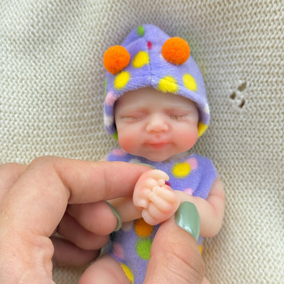 Poupée reborn miniature Pascale de 15 cm yeux fermés en silicone vêtue d'une tenue à pois violets
