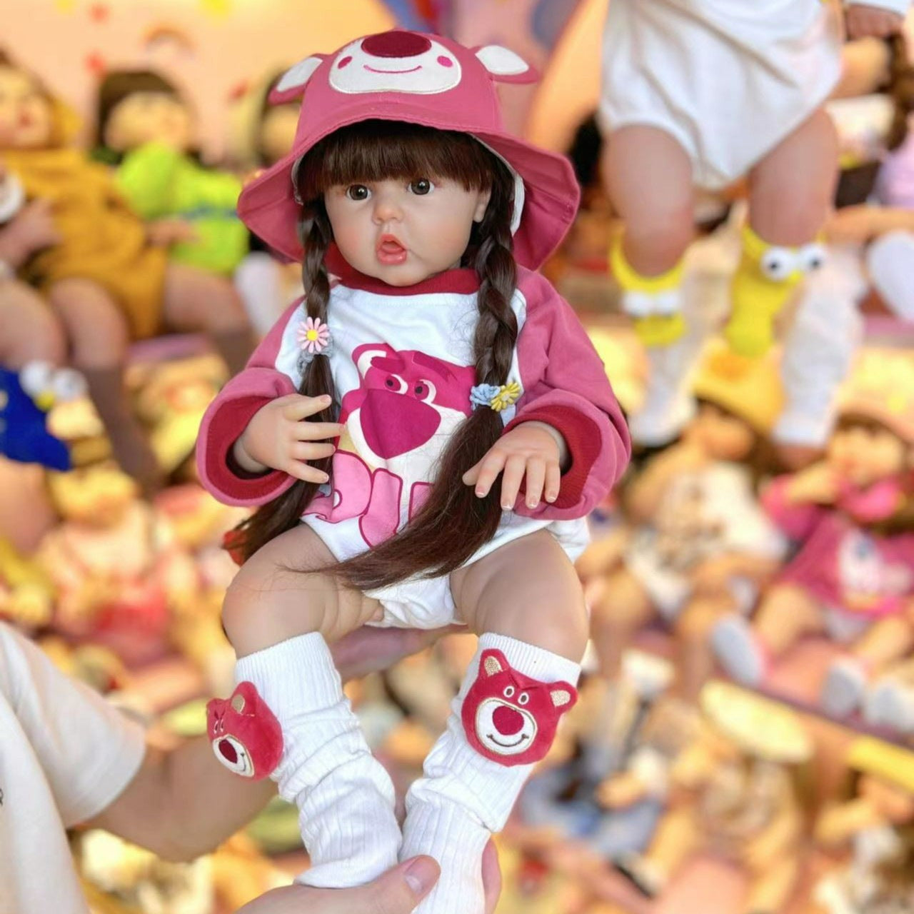 Bébé reborn fille de 55/60cm aux cheveux longs vêtue d'un adorable ourson rose