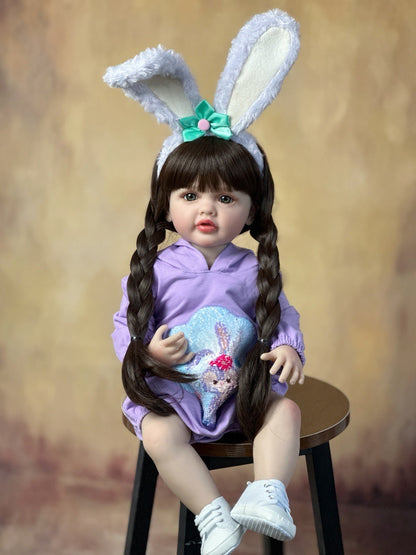Bébé reborn de 55 cm yeux ouverts longs cheveux vêtue de vêtements violets et d'un serre-tête à oreilles de lapin - Betty