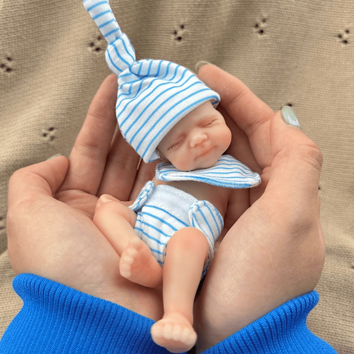 Poupée reborn miniature Pascale de 15 cm yeux fermés en silicone vêtue d'une tenue à rayures bleues