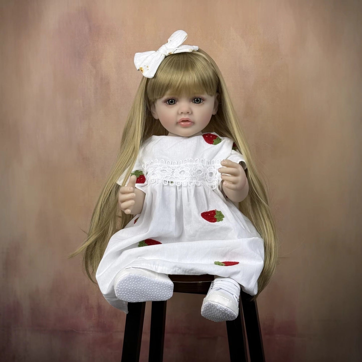 Bébé reborn Betty 55 cm yeux ouverts longs cheveux blonds en robe blanche