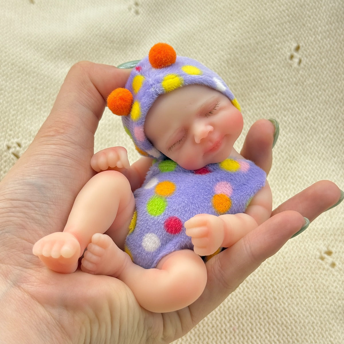 Poupée reborn miniature Pascale de 15 cm yeux fermés en silicone vêtue d'une tenue à pois violets