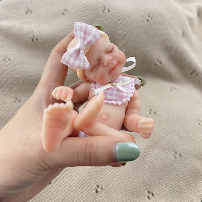 Poupée reborn miniature Pascale de 15 cm yeux fermés en silicone avec bavoir à carreaux roses