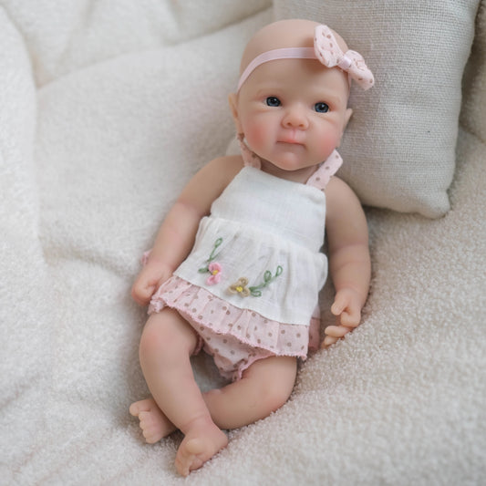 Bébé reborn Bettie fille de 20 cm en silicone souple vêtue d'une robe blanche