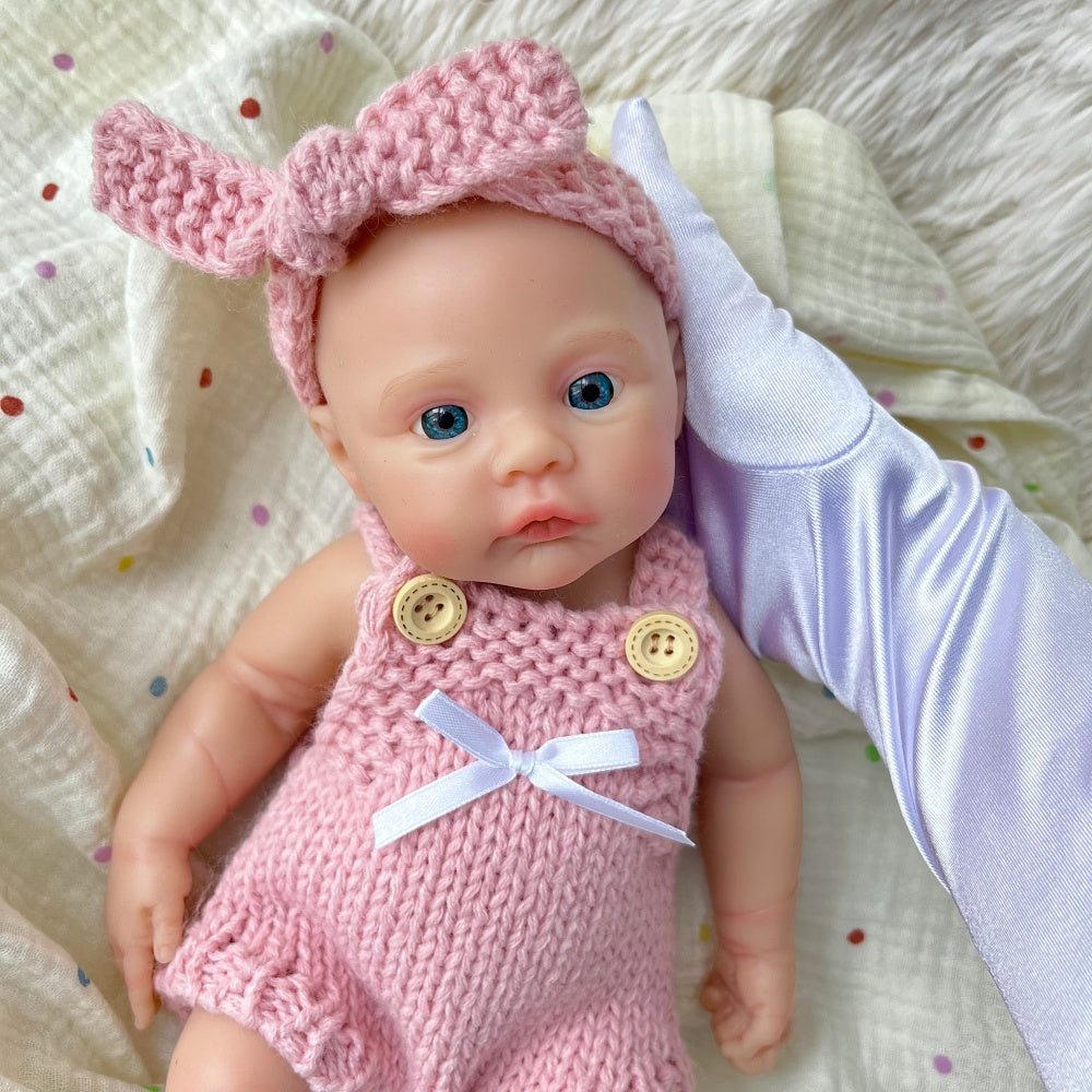 Bébé reborn fille de 30 cm en silicone vêtue d'une salopette rose tricotée
