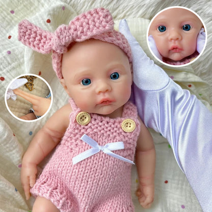 Bébé reborn fille de 30 cm en silicone vêtue d'une salopette rose tricotée