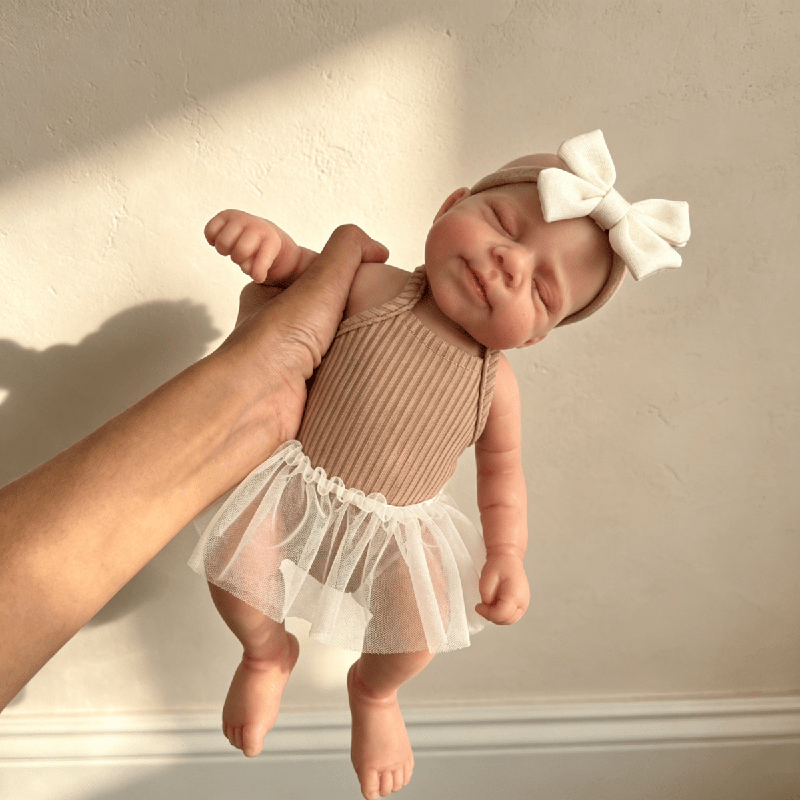 Poupée reborn Pascale en silicone de 30 cm endormie vêtue d'une robe marron
