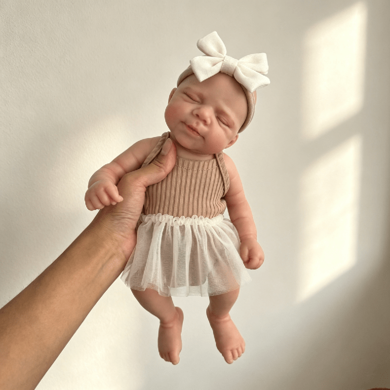 Poupée reborn Pascale en silicone de 30 cm endormie vêtue d'une robe marron