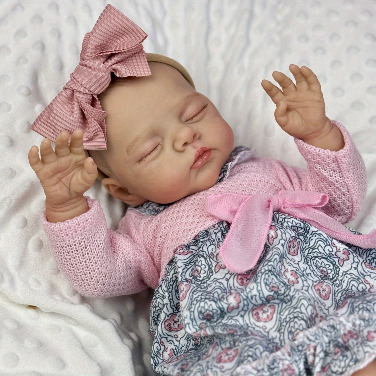 Poupée reborn Irys endormie corps souple de 48 cm en robe rose à fleurs