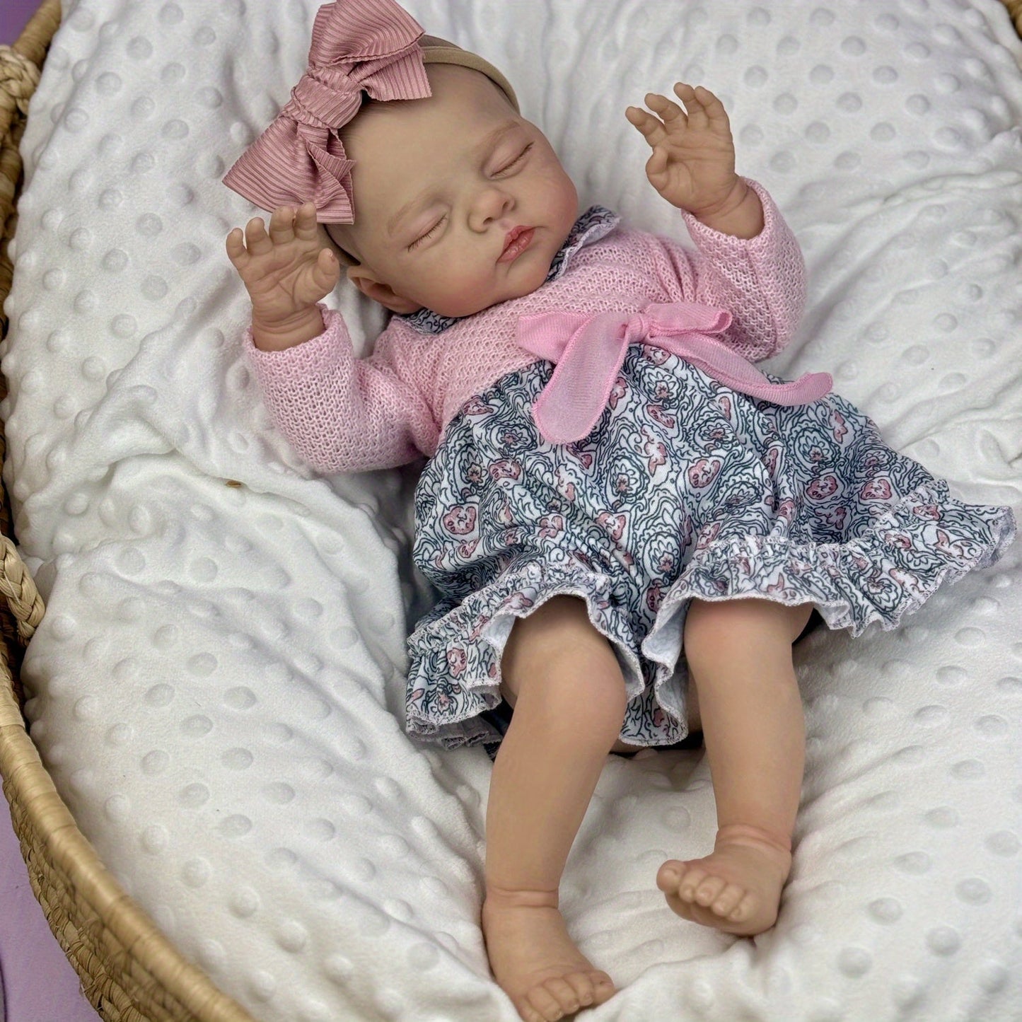 Poupée reborn Irys endormie corps souple de 48 cm en robe rose à fleurs